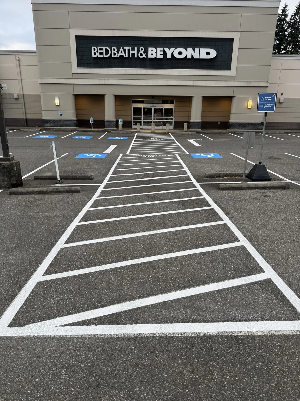 Freshly painted hatched ADA access aisle leading to a retail store entrance