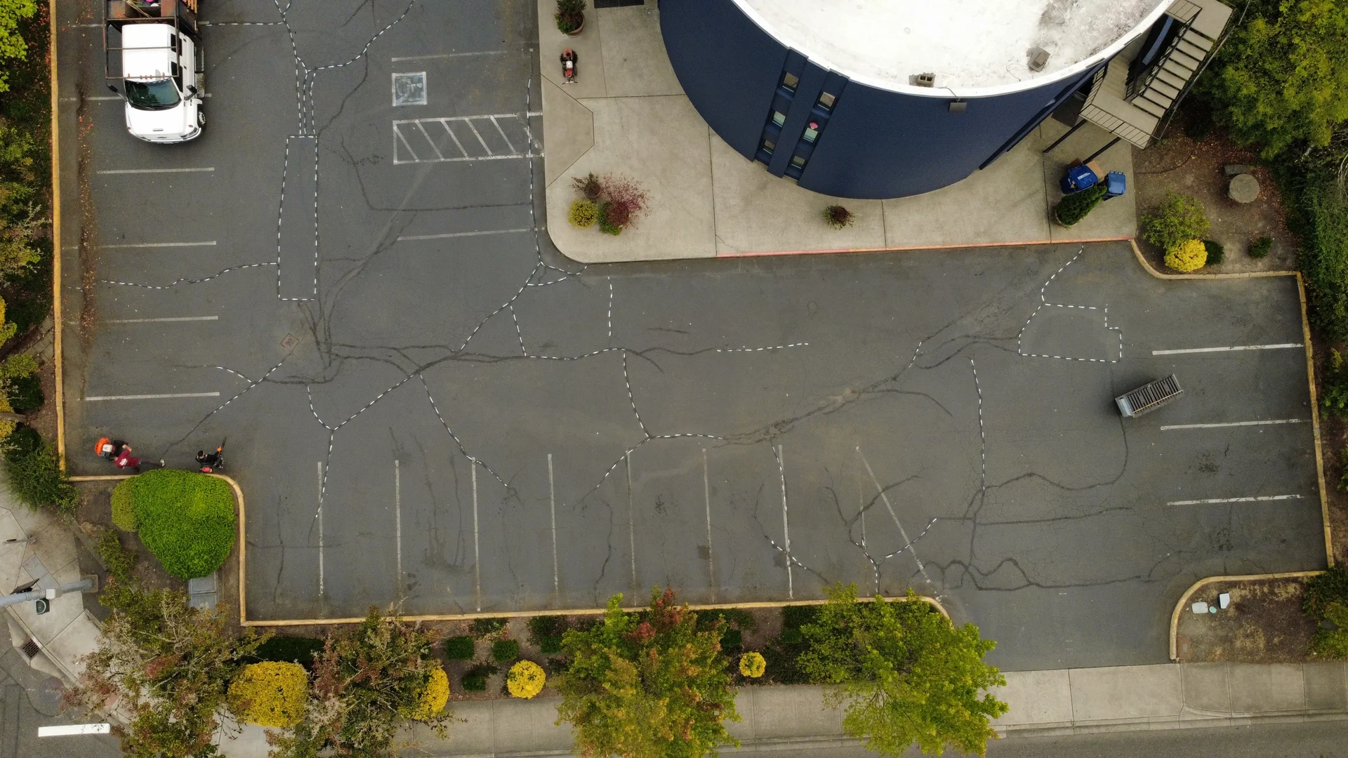 Before — faded Tukwila parking lot with a web of asphalt cracks prepped for sealing