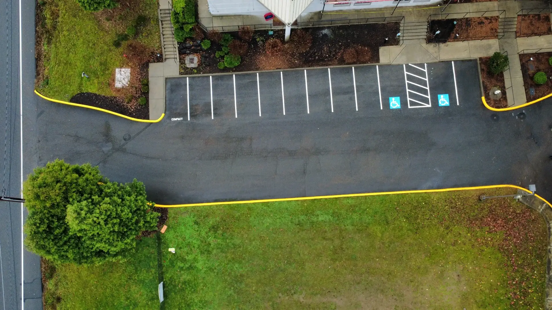 Maple Valley lot with new stalls, ADA spaces and yellow curbs, daytime aerial