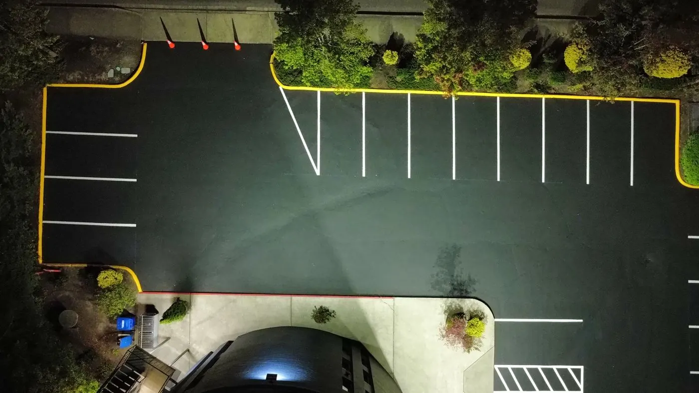 Top-down view of crisp new white parking stalls and freshly painted yellow curbs