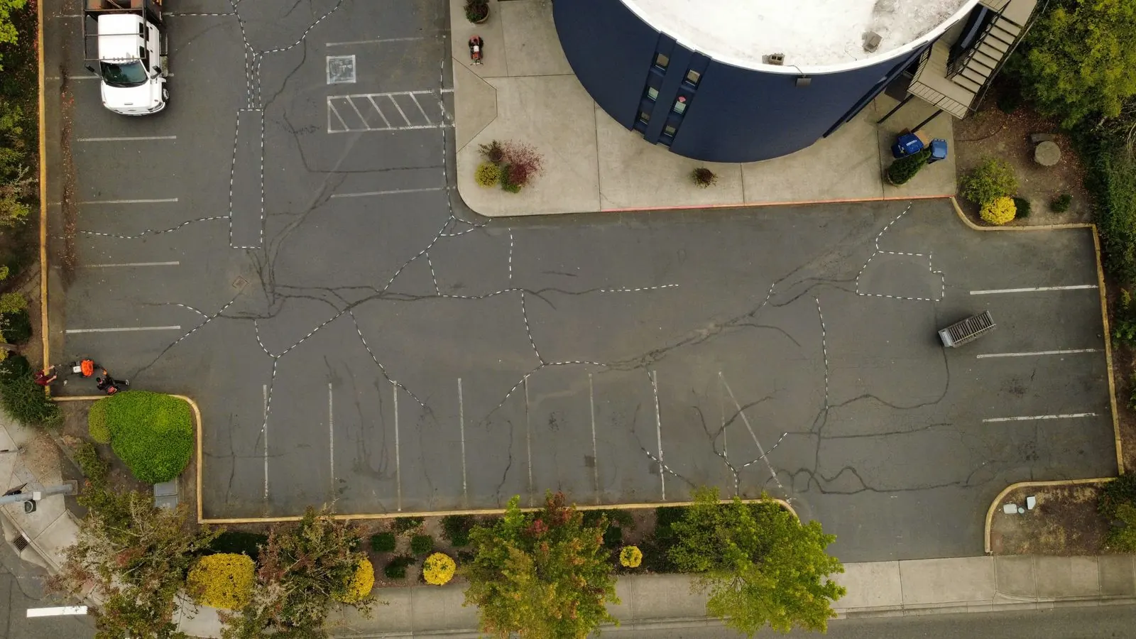 Before — faded parking lot with cracked asphalt and worn line striping