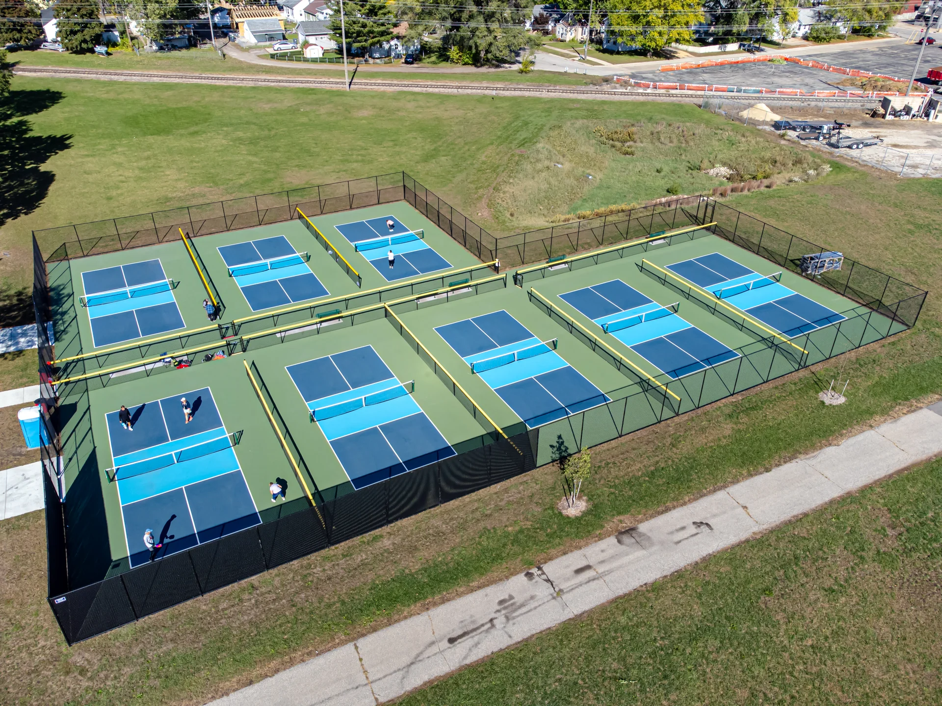 Aerial view of eight freshly striped blue pickleball courts with crisp white lines
