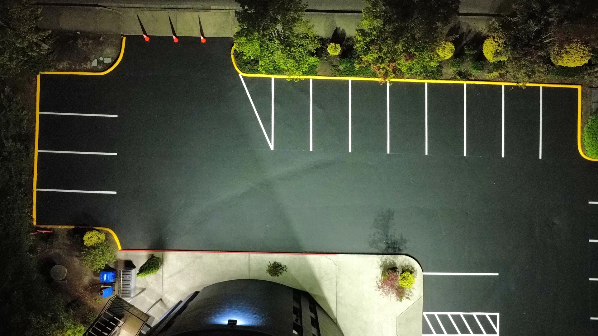 Aerial night view of freshly painted yellow curbs on a sealcoated lot